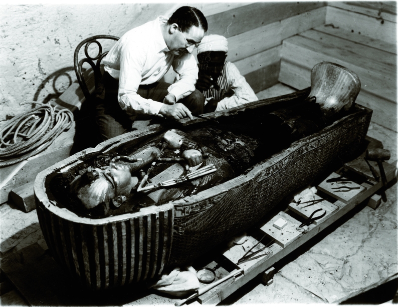Fotografía de Harry Burton en la que Howard Carter inspecciona el sarcófago de Tutankhamón.